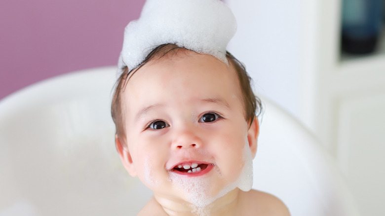 Baby in bath with suds on hair