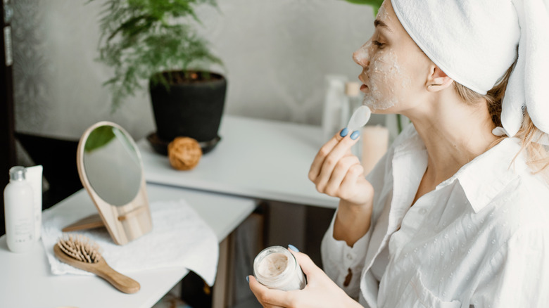 young woman applying face mask