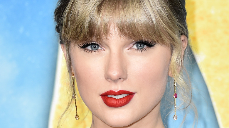 Taylor Swift wearing red lipstick posing for a picture