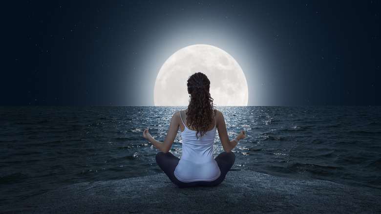 Woman meditating by the moon
