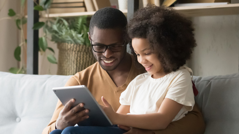 Father and daughter looking at a tablet 