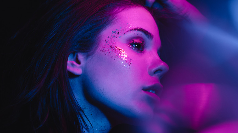 Side profile of woman with glitter highlighter on cheekbones
