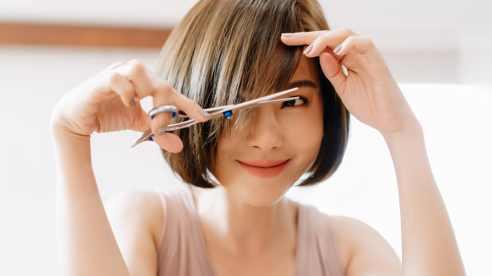 Woman cutting her bangs