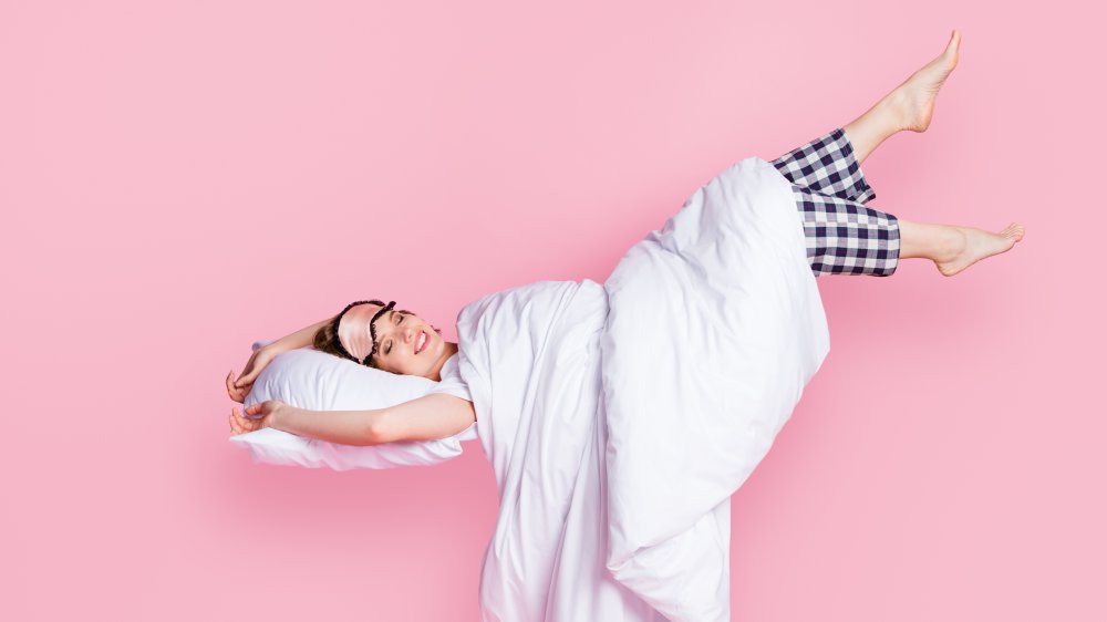 A woman floating happily into bed 