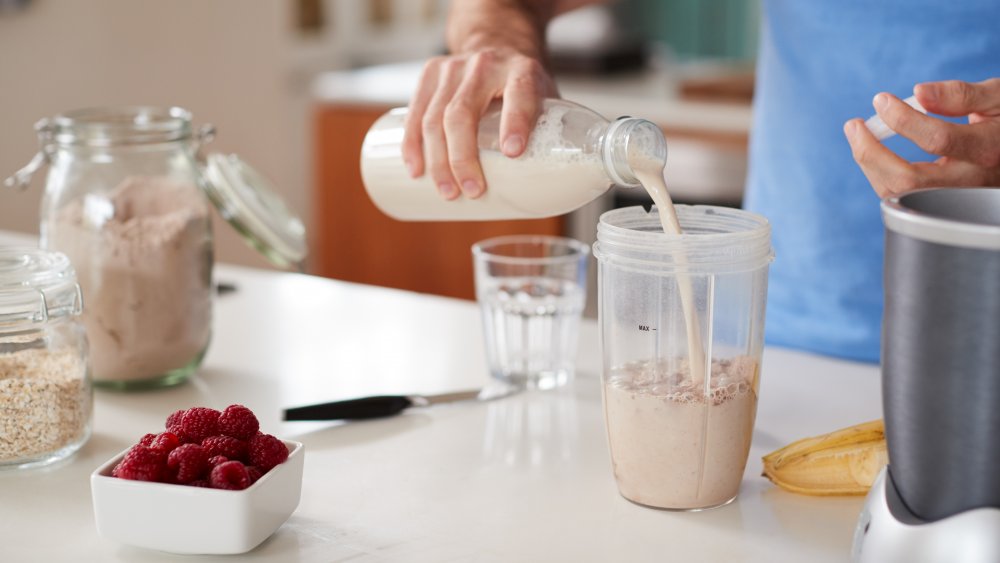 Man pouring oat milk