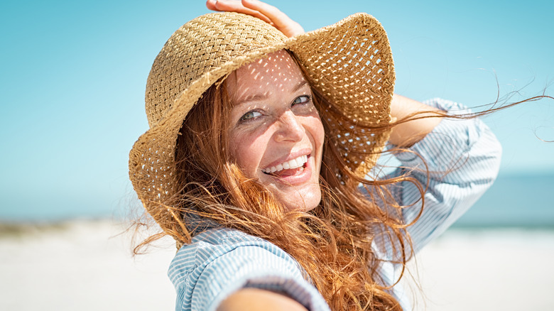 A woman in a sunhat at the beach 