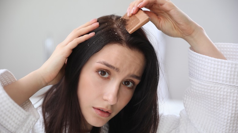A woman combing her hair with flakes