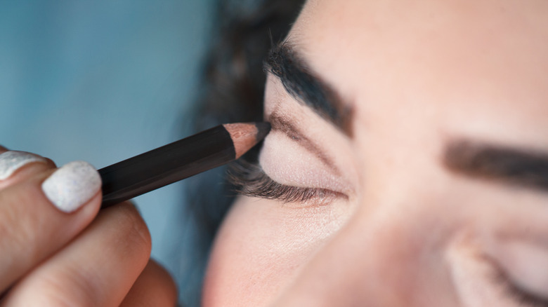 Woman having eye make-up applied