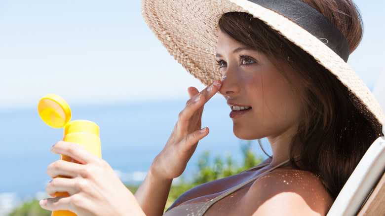 woman applying sunscreen to face