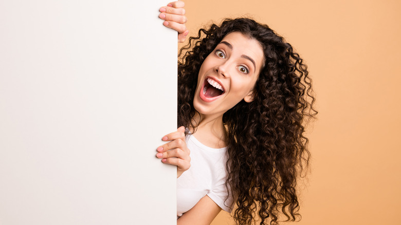 Excited woman with long curly hair