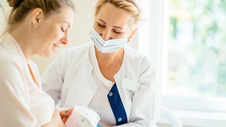 doctor helping breastfeeding mother