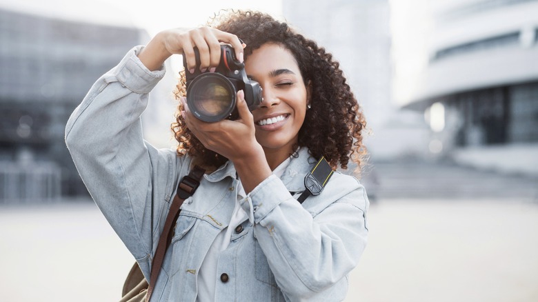 Young woman taking outdoor photos with a camera