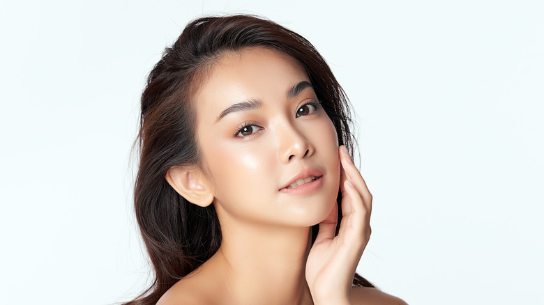 A woman touching her clear face with her hand 