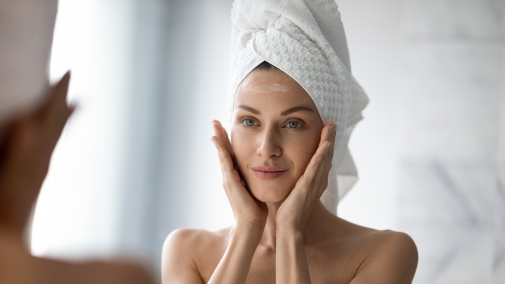 Woman applying moisturizer