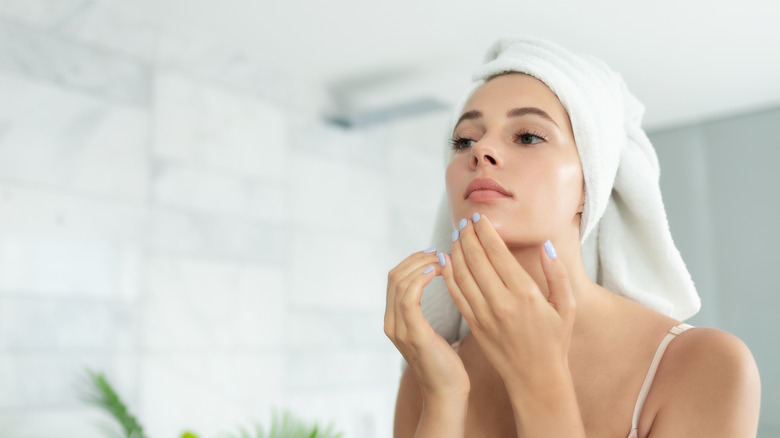 Woman applying serum to skin