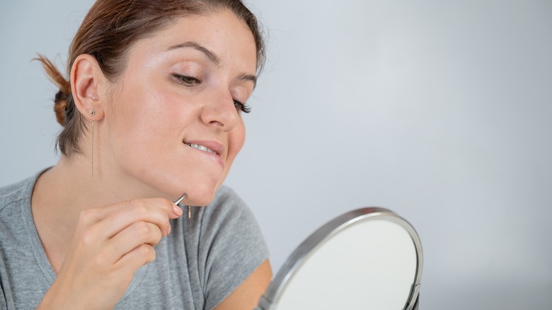 Woman plucking chin hair