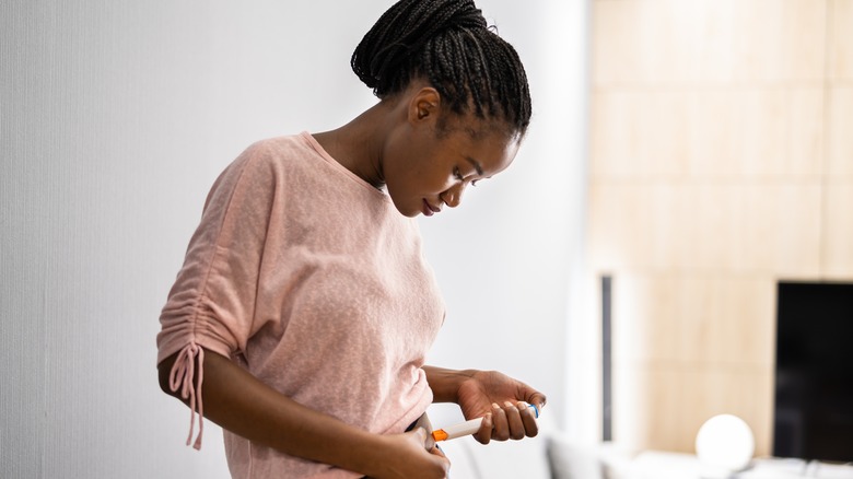 woman using IVF syringe on abdomen