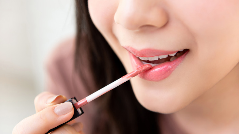 woman applying liquid lipstick