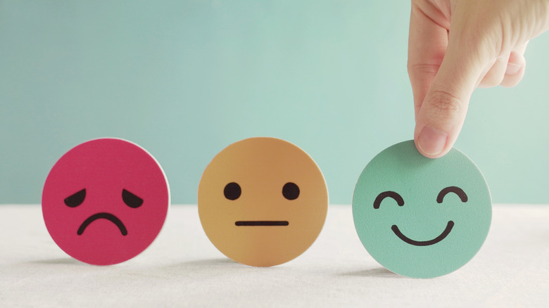 hand choosing happy face