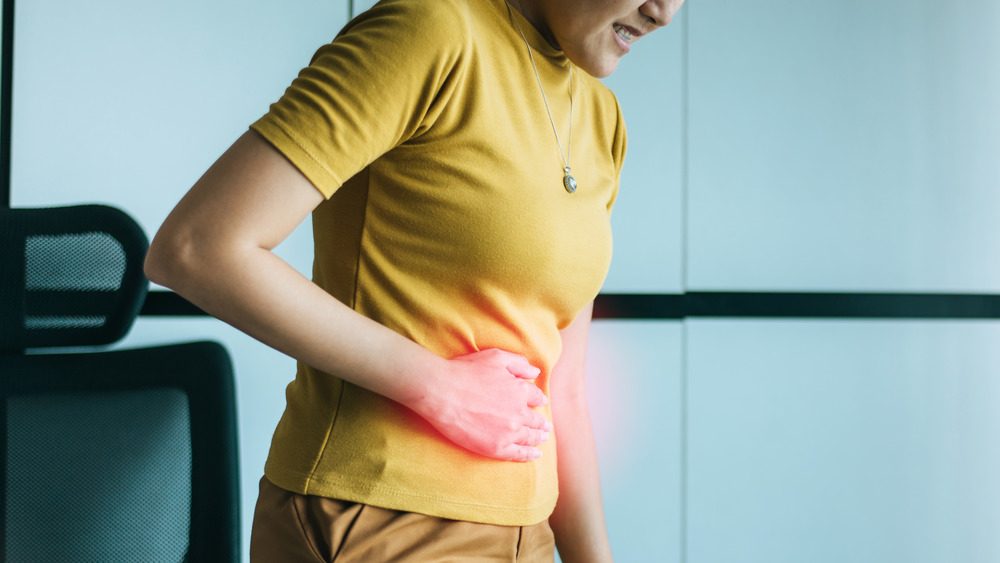 Woman holding stomach in pain