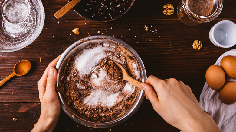 A woman mixing ingredients to make brownie batter