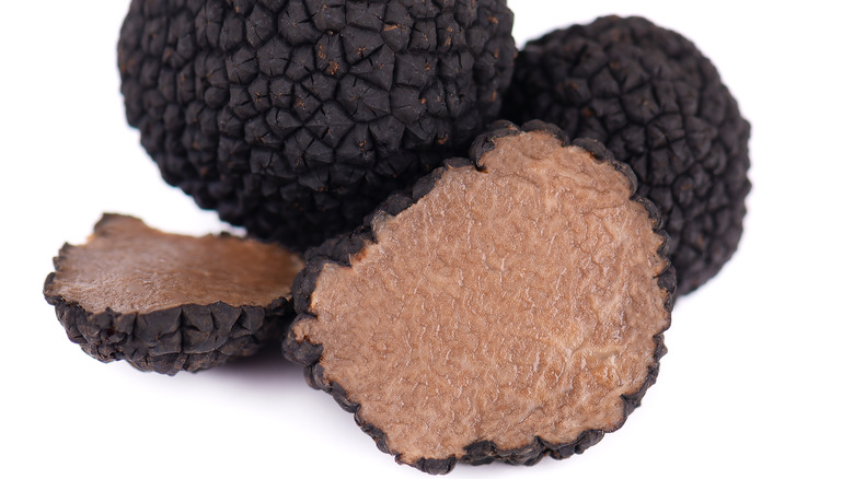 Whole and sliced black truffles