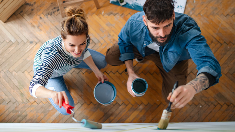 Couple painting a wall together