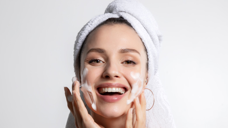 woman washing face and smiling