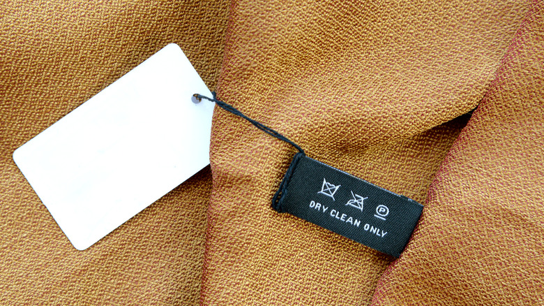 Clothing label on woven gold and red silk fabric