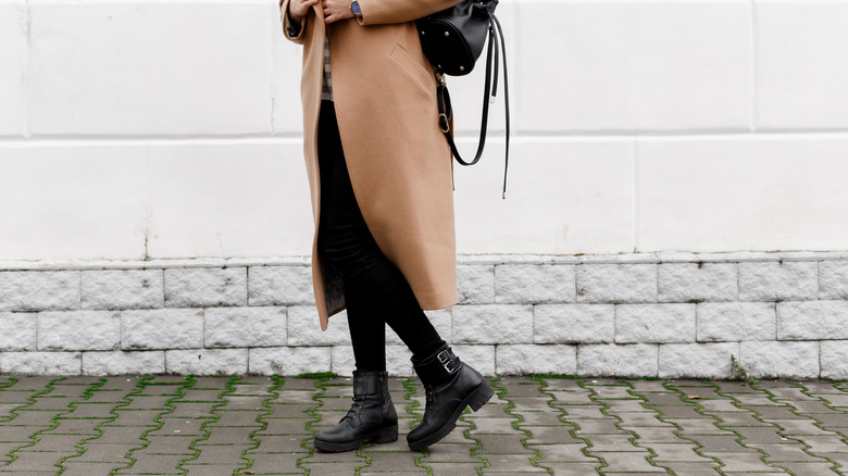 woman wearing a coat and leggings with boots