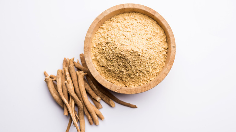 Ashwagandha powder in a bowl against a white backdrop