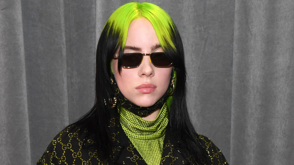 Billie Eilish sporting green hair and sunglasses 