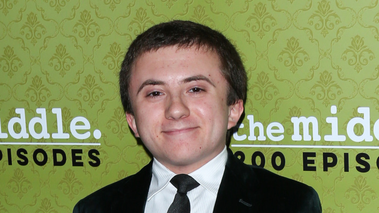 Atticus Shaffer smiling on "The Middle" step-and-repeat