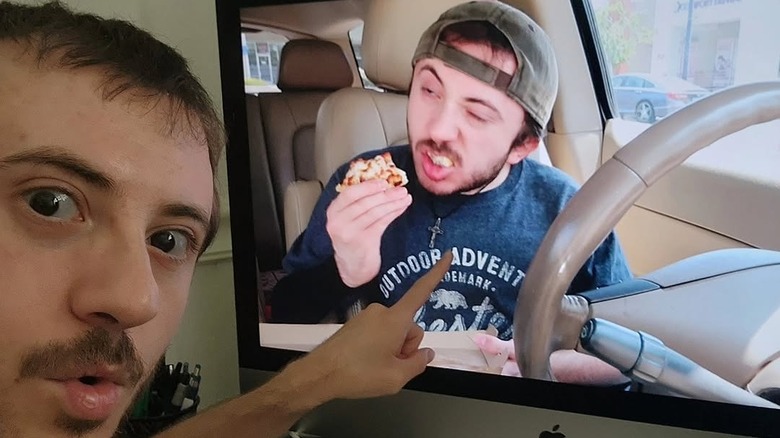 Atticus Shaffer pointing to a computer screen of him eating pizza in a YouTube clip
