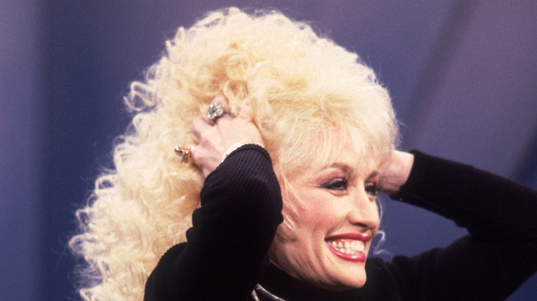 Dolly Parton holding wig 