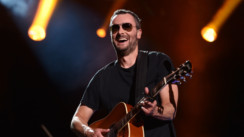 Eric Church smiling with guitar