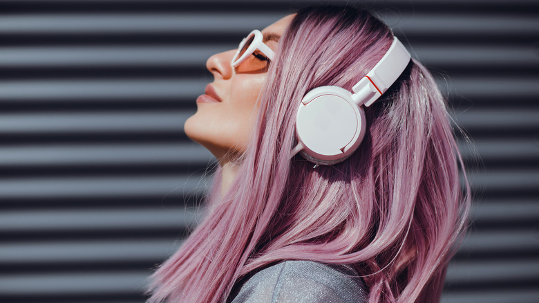 Pink-hair woman wearing white headphones