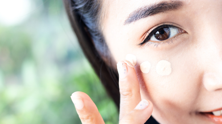 woman applying eye brightener 