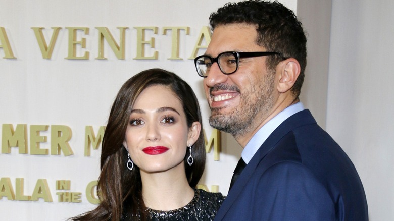 Emmy Rossum and her husband Sam Esmail walk a red carpet