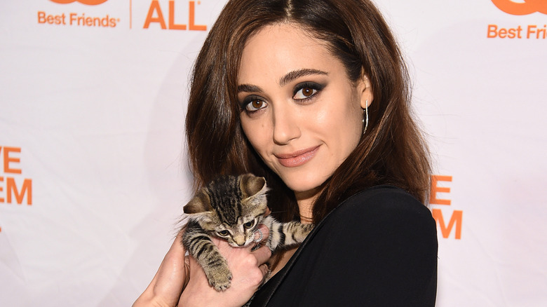 Emmy Rossum posing with a kitten at a Best Friends Animal Society event in 2019