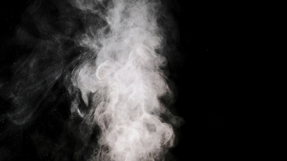 smoke puffing upwards with a black background 