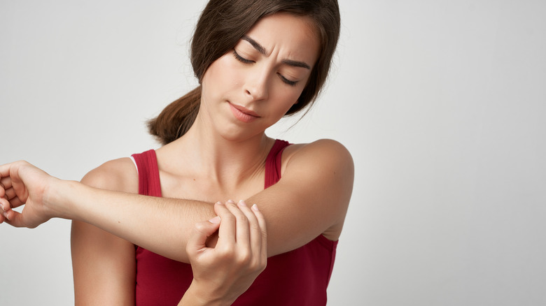 concerned woman looking at her arm