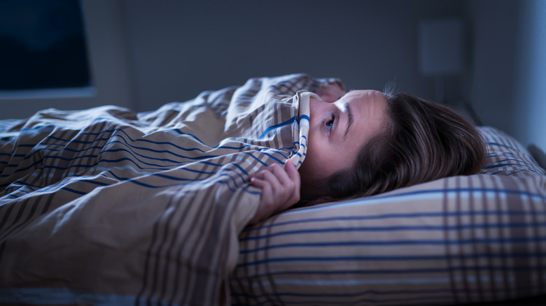 woman hiding bed