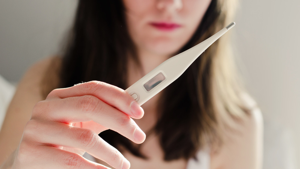 Woman taking her temperature