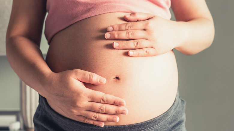 Pregnant woman holding belly