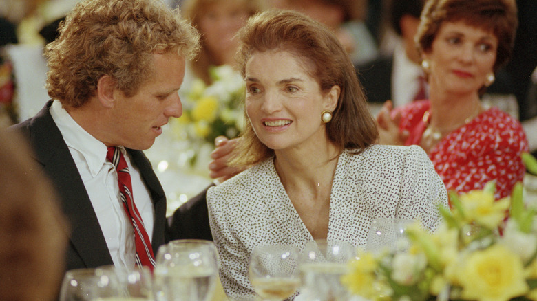 Joe Kennedy speaking with Jackie Onassis at formal dinner