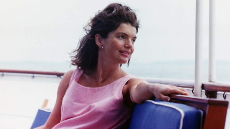 Jackie Kennedy sitting on a yacht with her hair blowing in the breeze