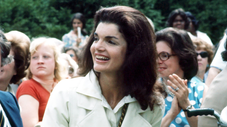 Jackie Kennedy smiling in a crowd of people