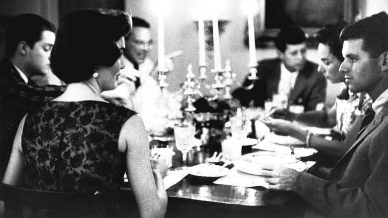Jackie and Robert Kennedy talking at a family dinner