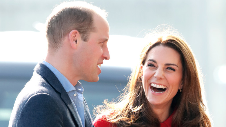 Prince William and Kate Middleton smile at an event. 